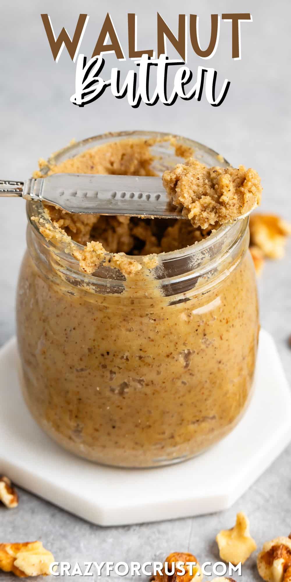 walnut butter in a clear jar with a spoon scooping it out with words on the image.