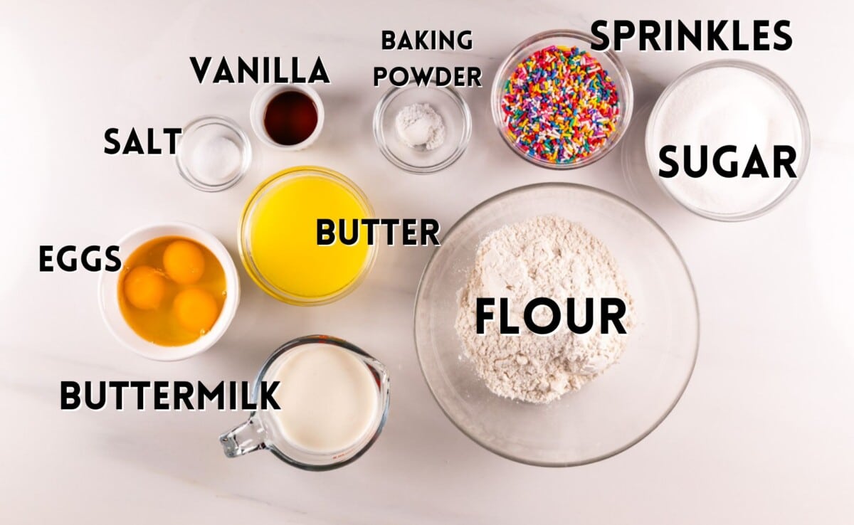 ingredients in birthday cupcakes laid out on a white counter.