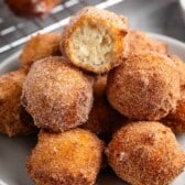 stacked donut holes on a grey plate.