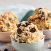 cookie dough mixed with chocolate chips in pastel colored bowls.
