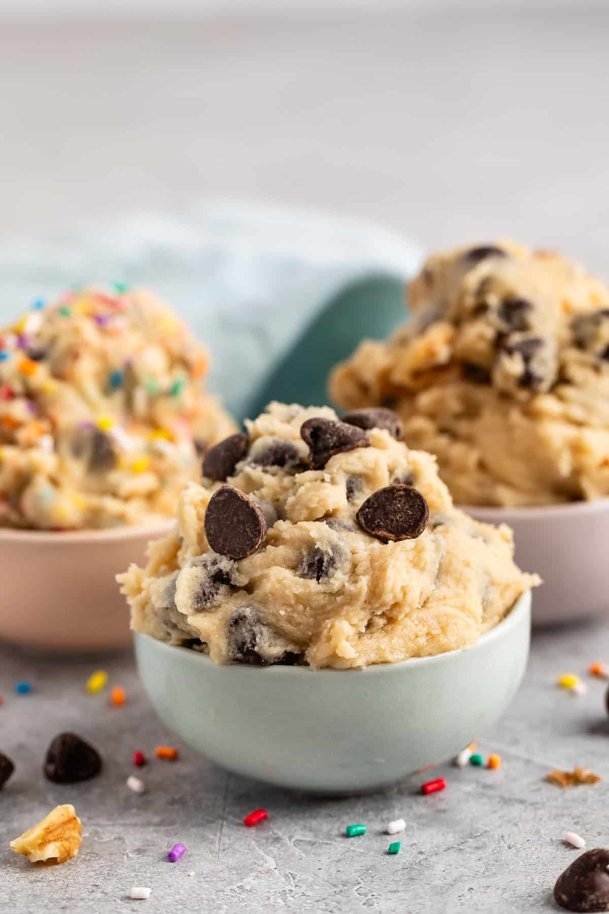 cookie dough mixed with chocolate chips in pastel colored bowls.