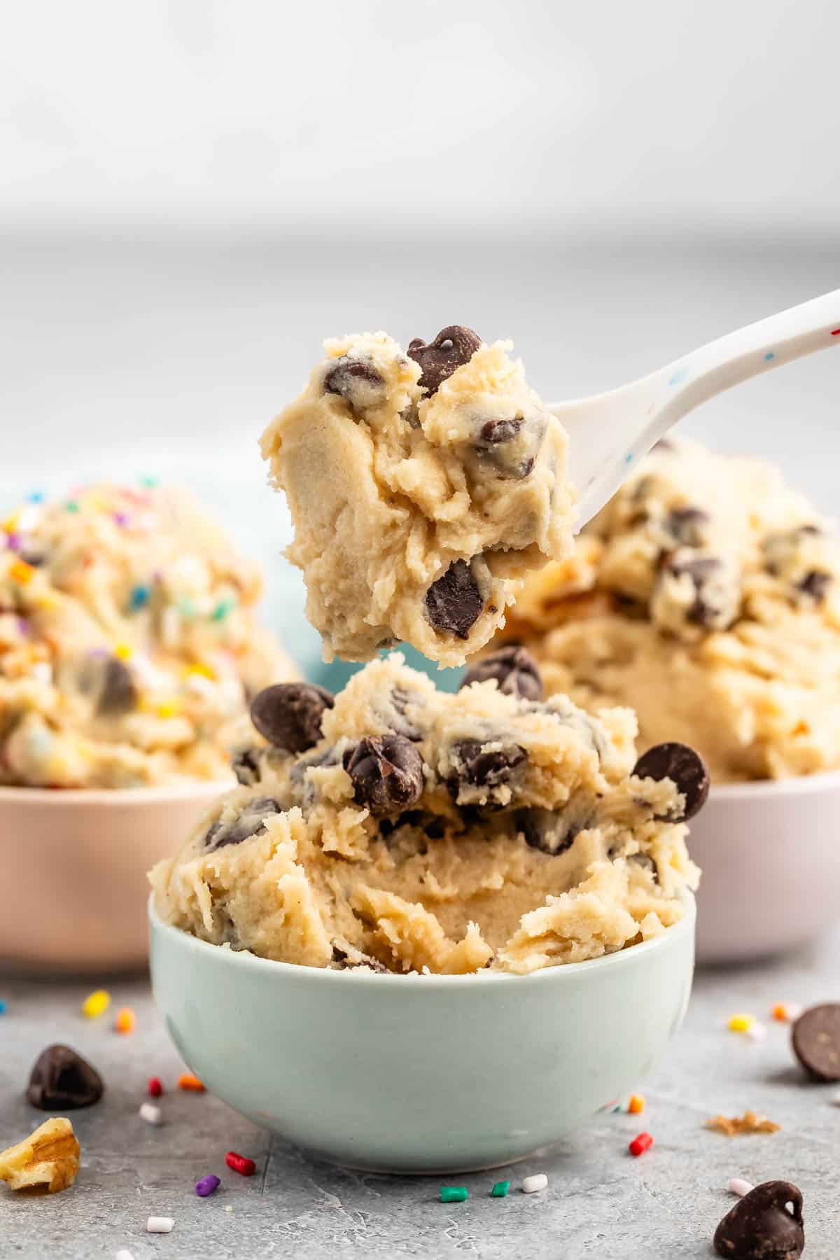 cookie dough mixed with chocolate chips in pastel colored bowls.