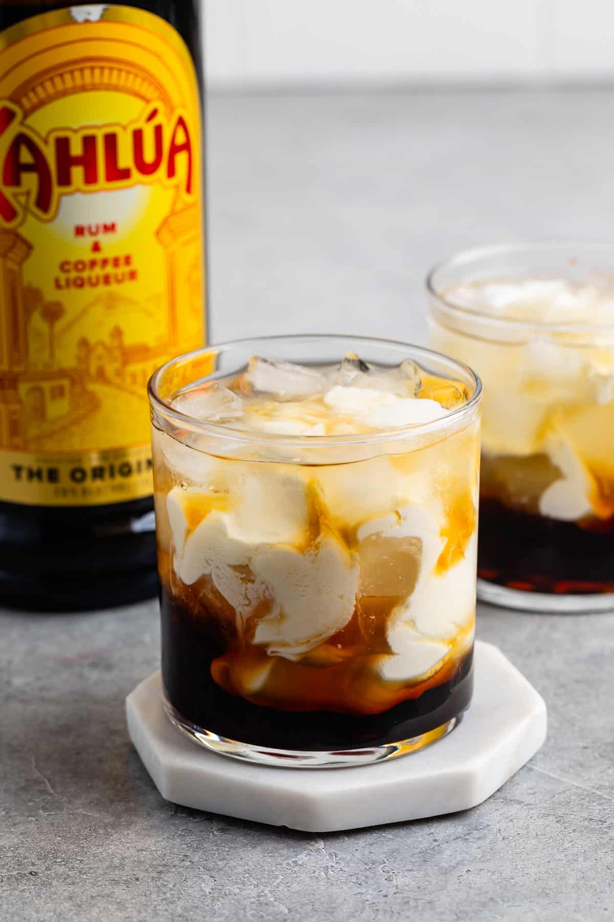 short clear glass with white and brown drink in the glass.