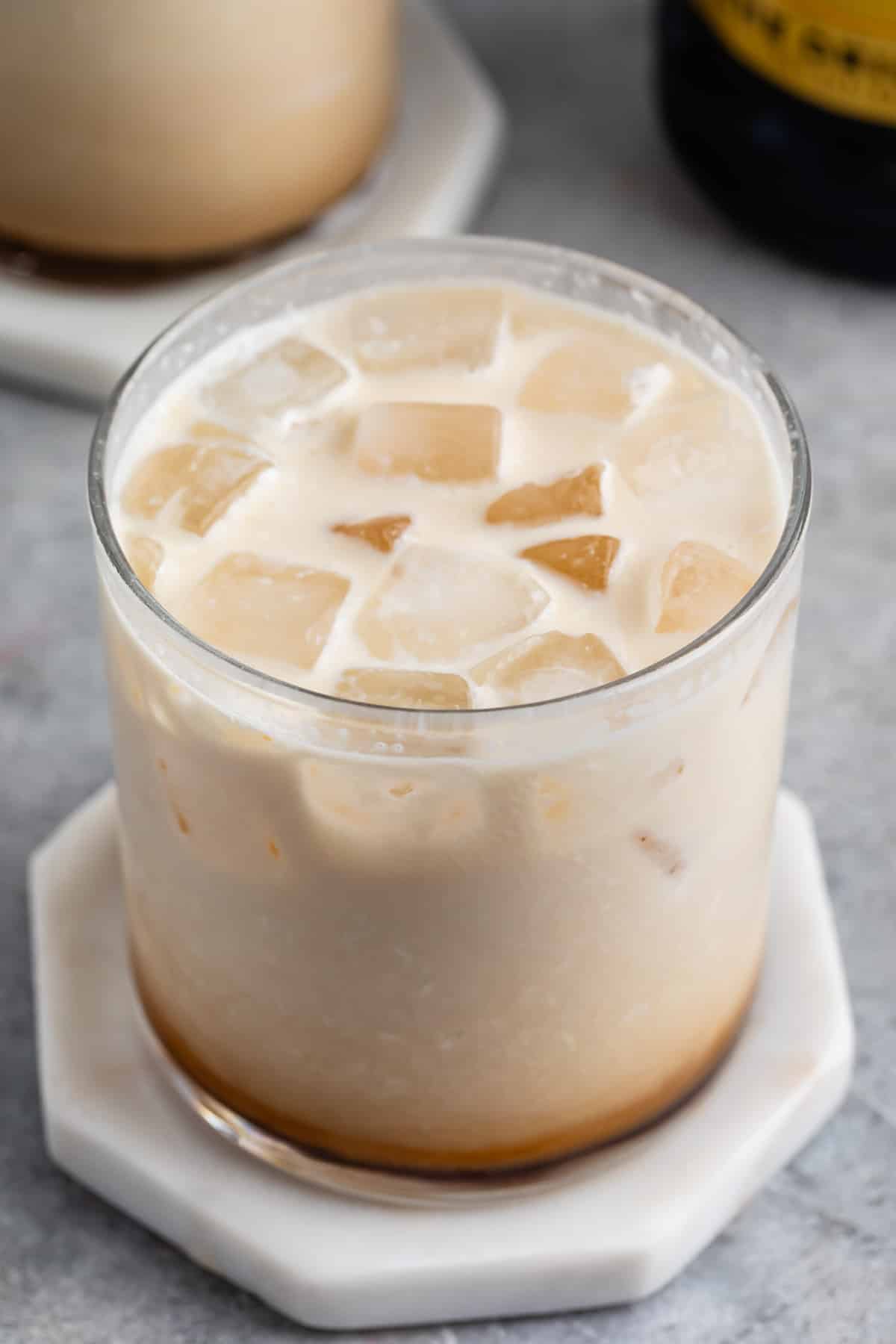 short clear glass with white and brown drink in the glass.