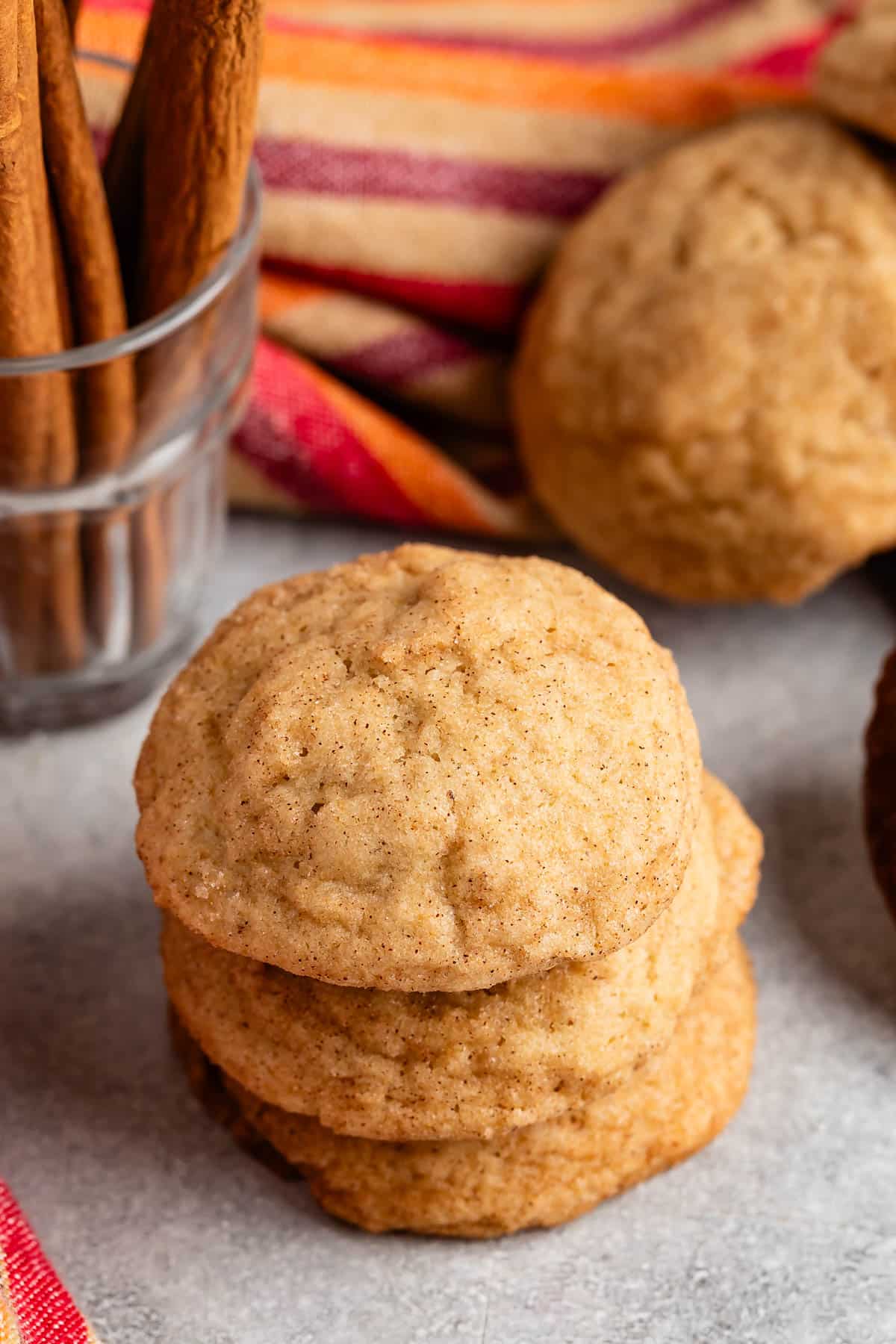 stacked snickerdoodles on a grey surface.