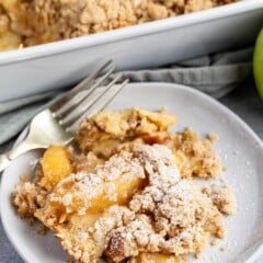 apple pie casserole on a grey plate with a crumble in top.