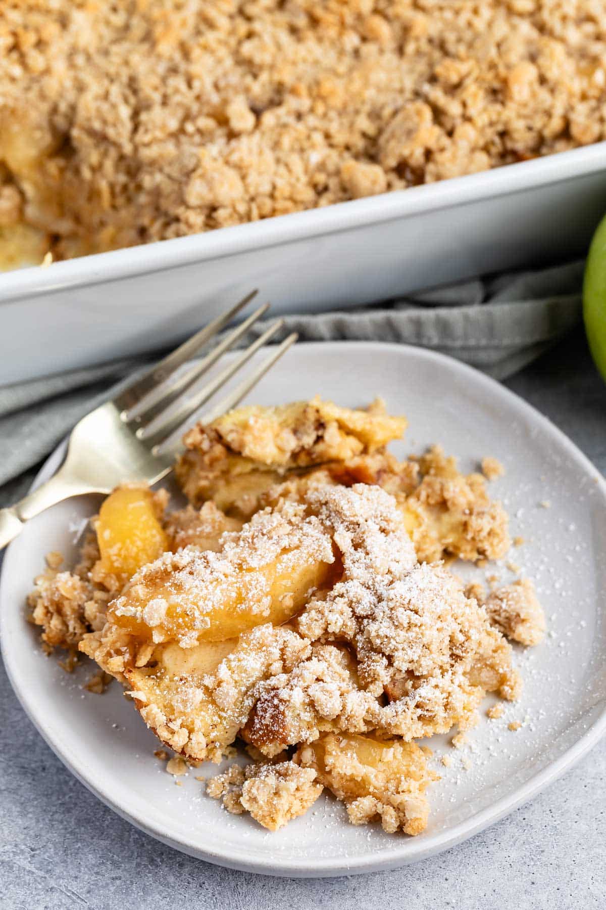 apple pie casserole on a grey plate with a crumble in top.