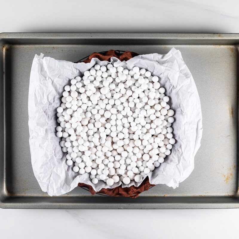 pie weights in pie crust on cookie sheet.