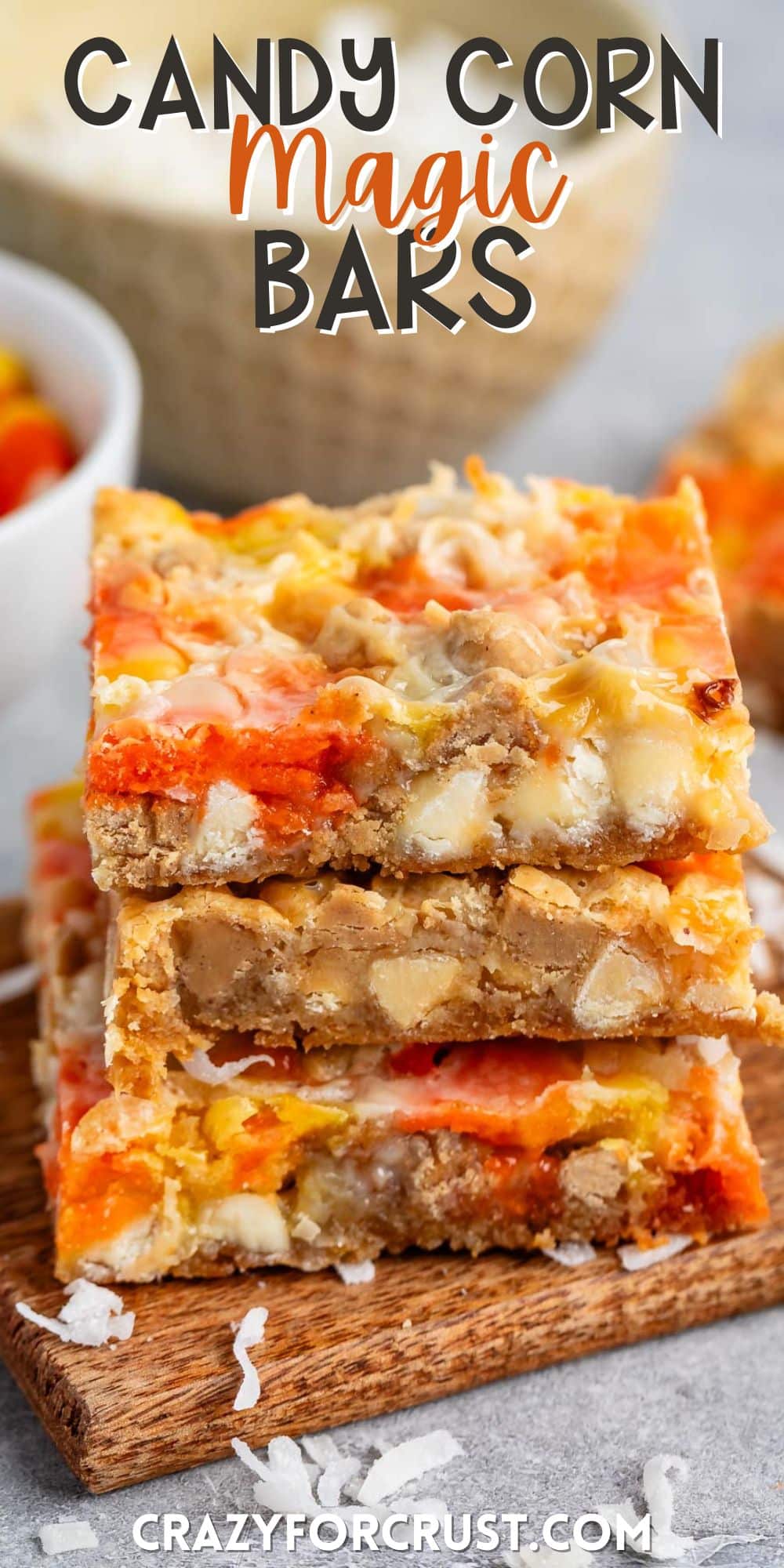 stacked candy corn magic bars with candy corn and coconut baked in with words on the image.