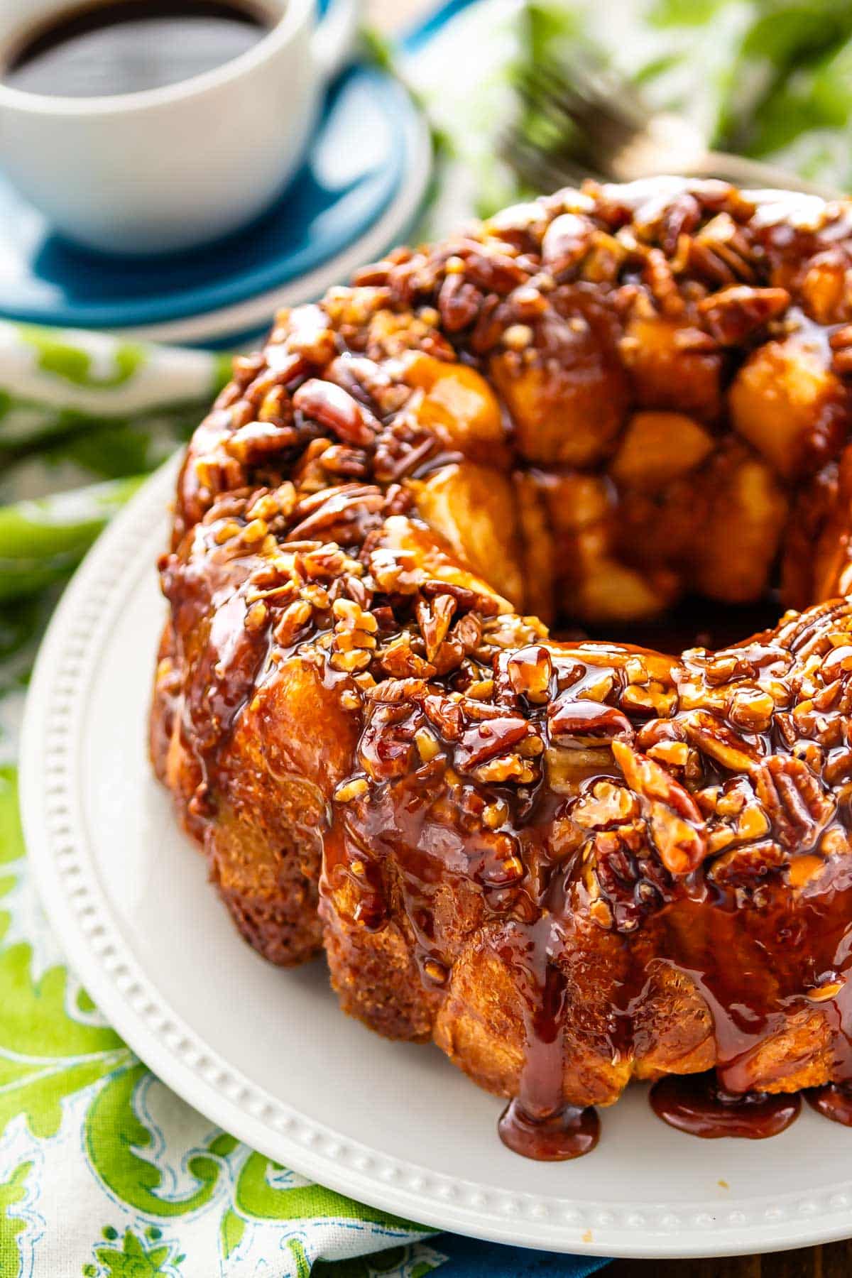 monkey bread on a white plate covered in nuts.