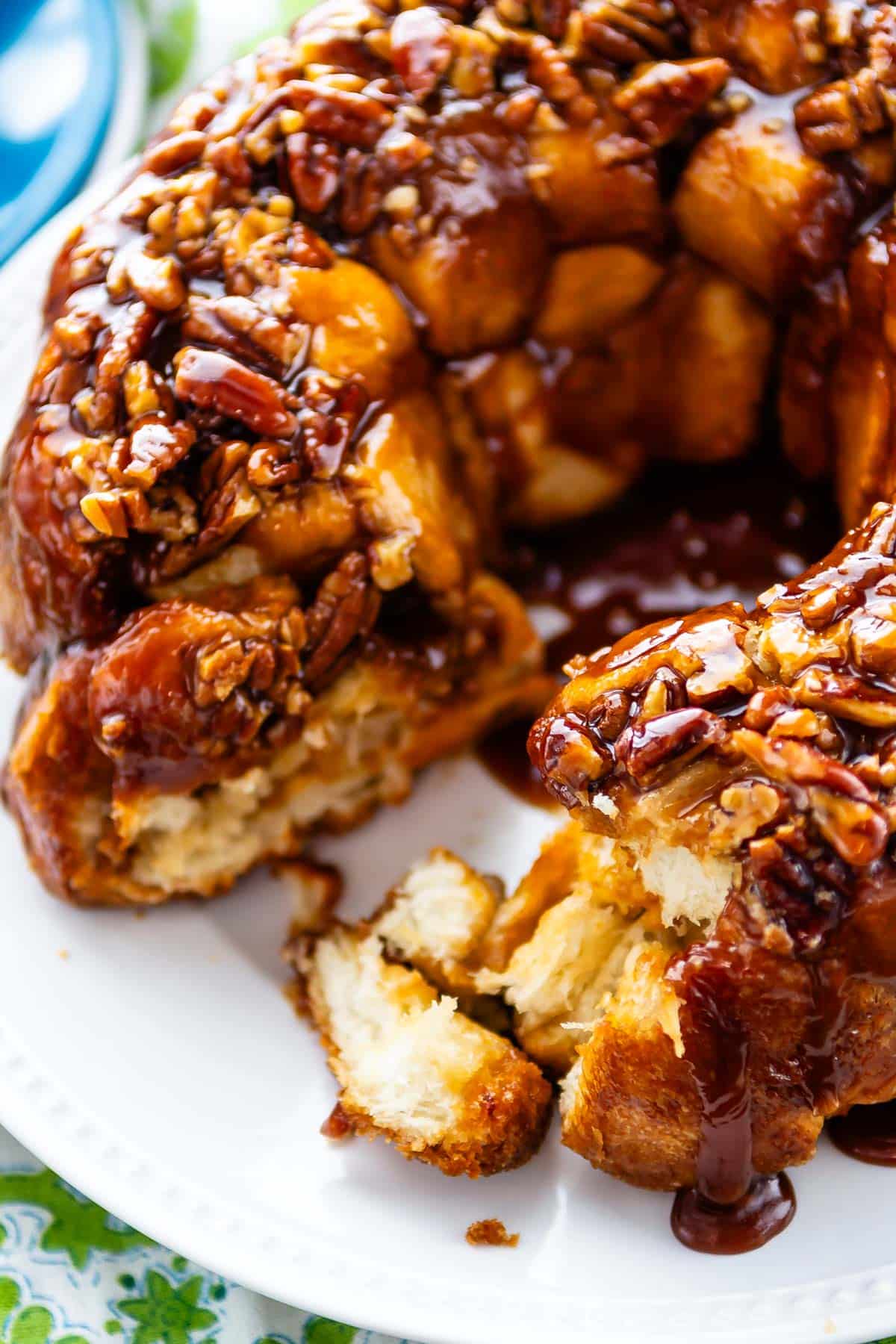 monkey bread on a white plate covered in nuts.