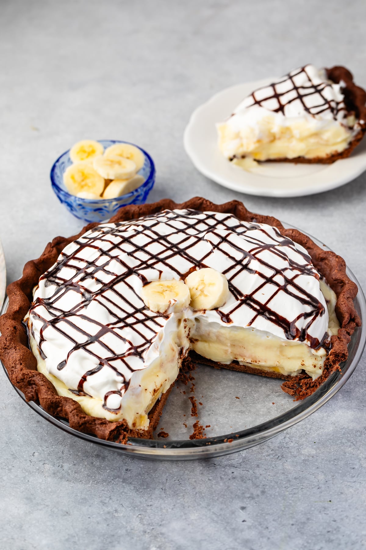 banana cream pie with chocolate crust and slice missing.