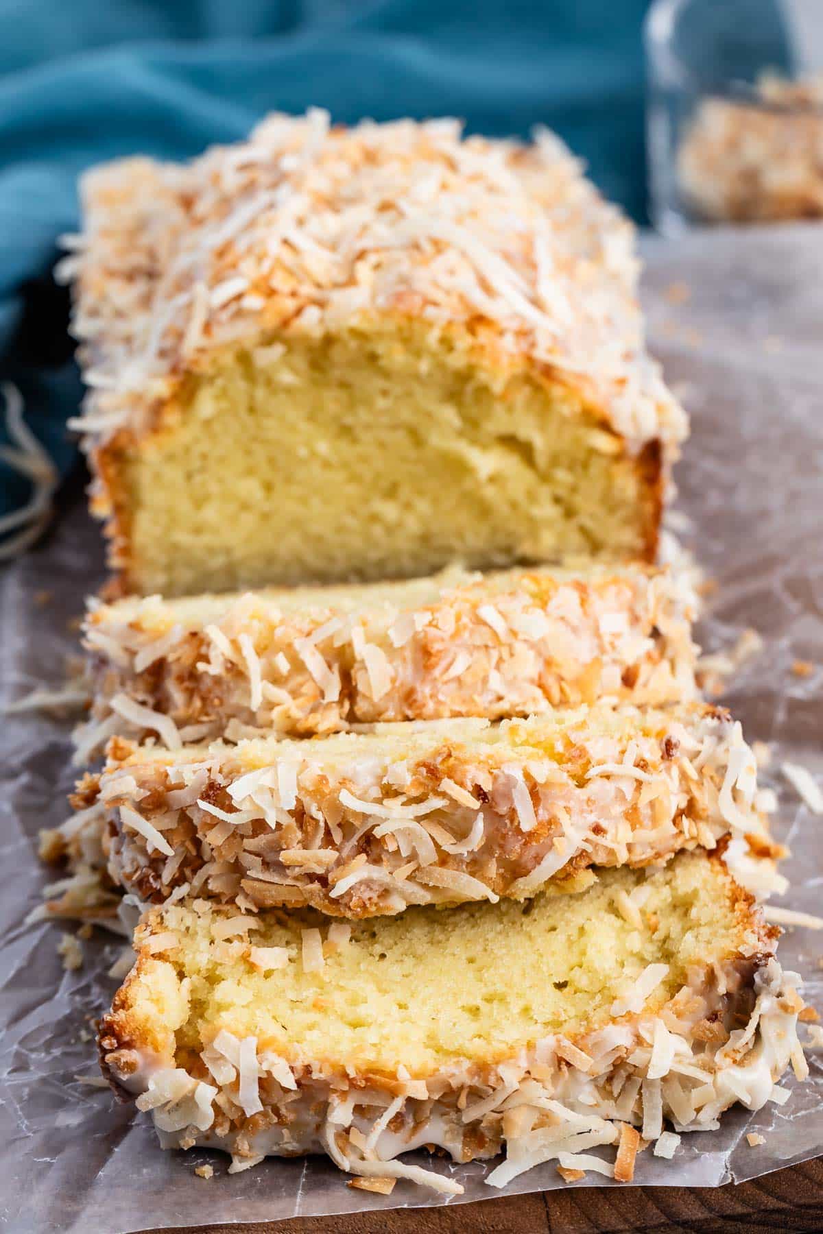 sliced coconut pound cake with toasted coconut on top.