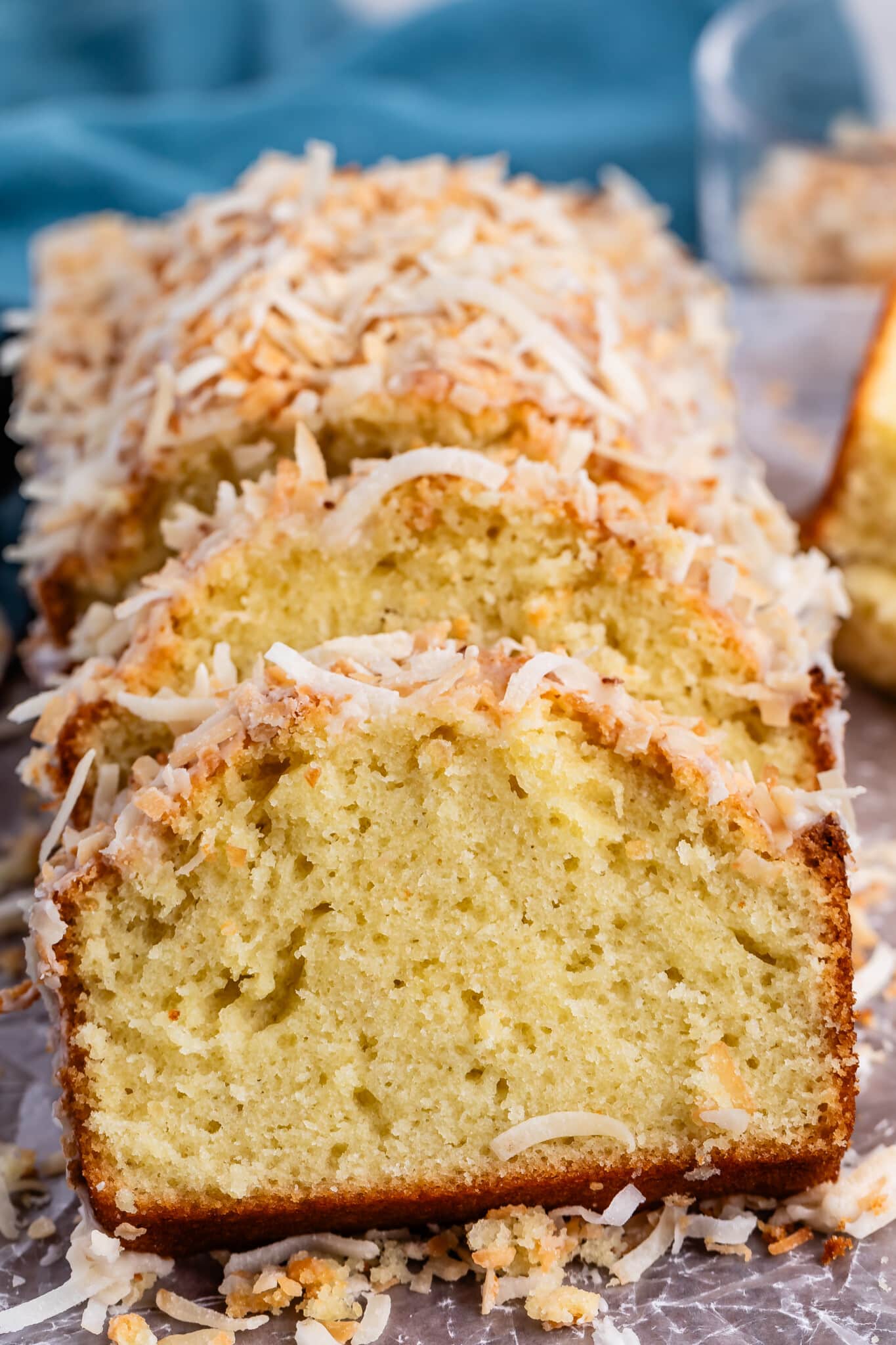 sliced coconut pound cake with toasted coconut on top.