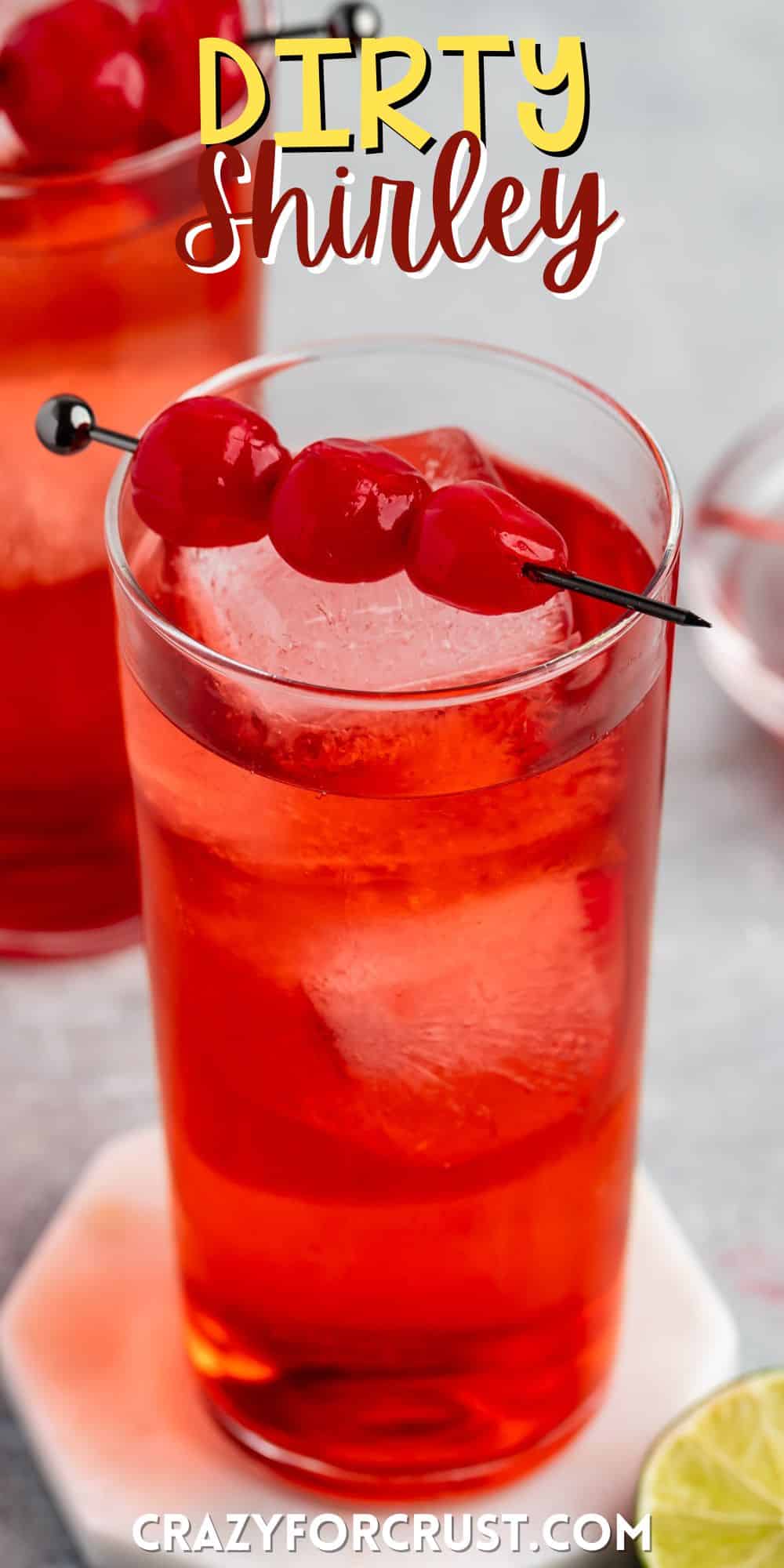 shirley temple in a tall clear glass with cherries along the top with words on the image.