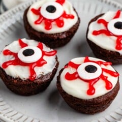 brownies bites with a white frosting, red gel, and candy eyeball on top.