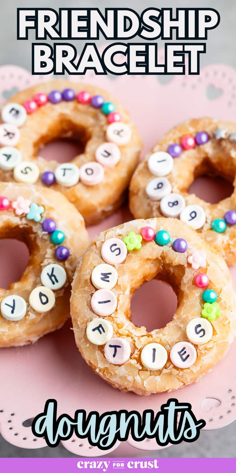 4 doughnuts on pink cake plate with sprinkles and candy Pinterest pin.