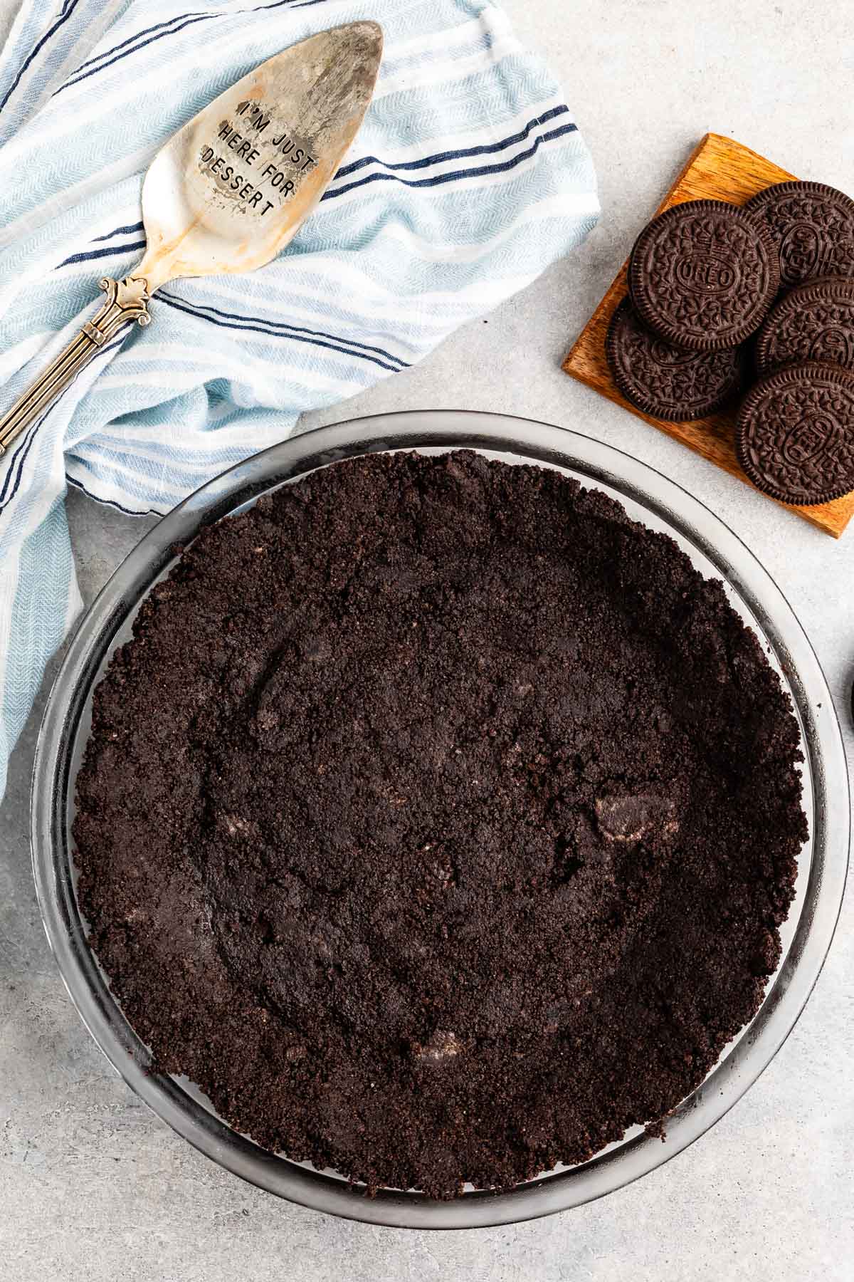 Oreo cookies pressed into a clear pan making an Oreo crust.