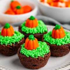 brownie bites topped with green frosting and a pumpkin candy corn.