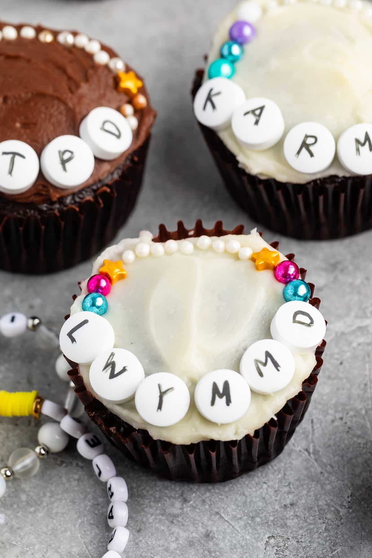 cupcake with white frosting and LWYMMD decorated with candy friendship bracelet.