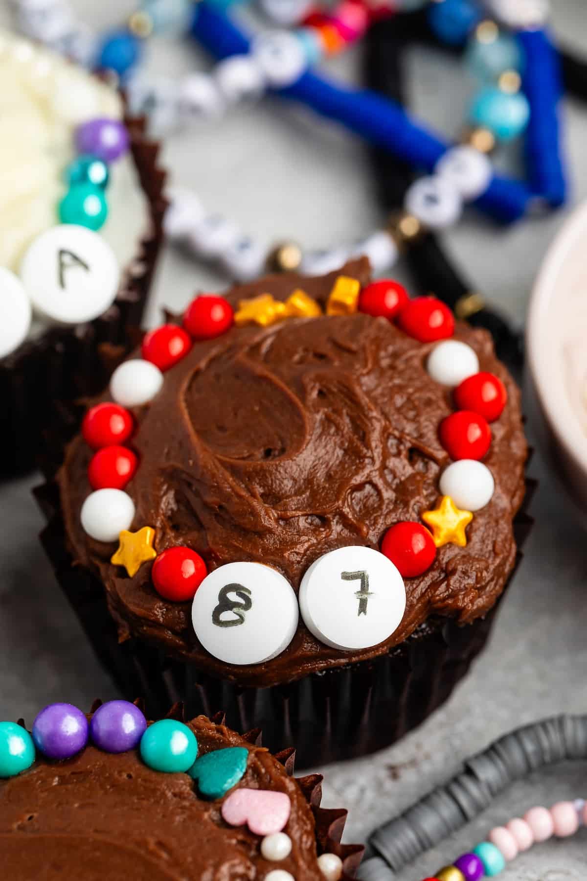 cupcake with chocolate frosting and 87 decorated with candy friendship bracelet.