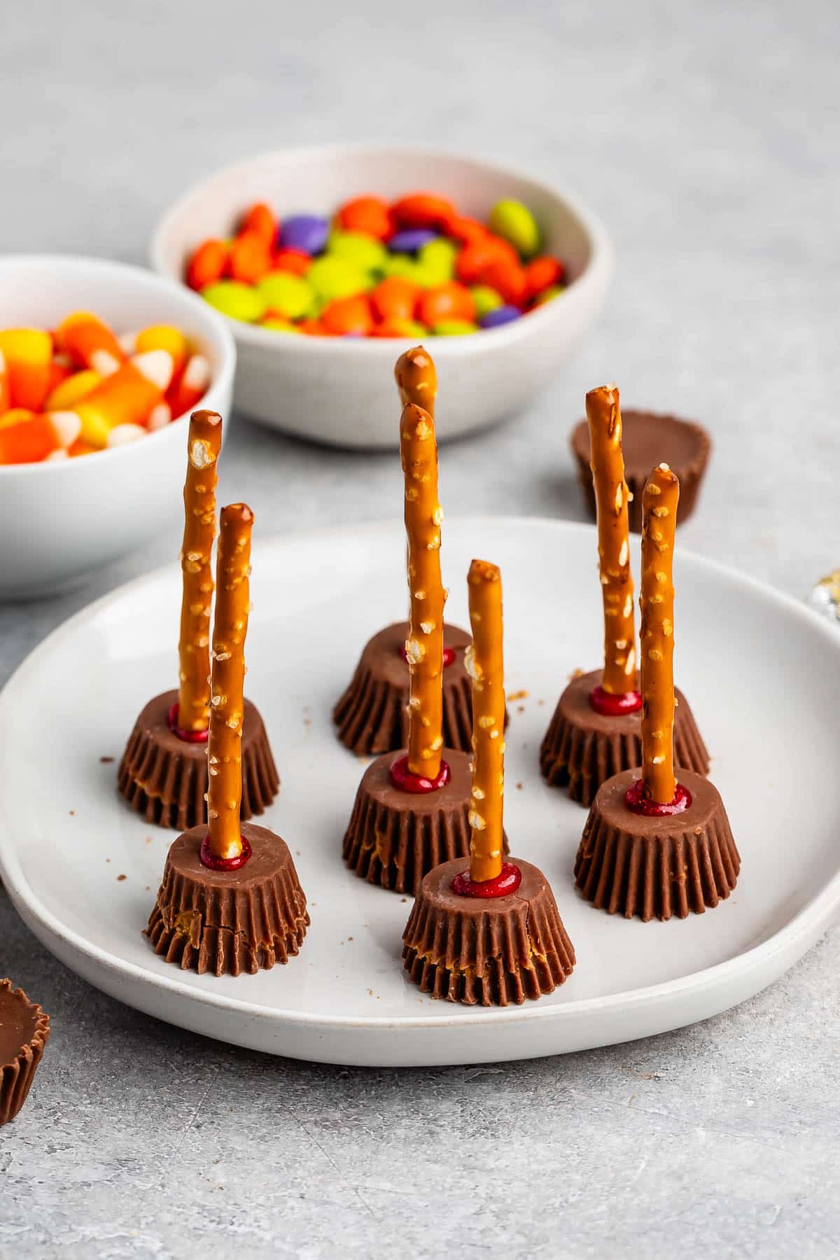 Reeses peanut butter cups with a pretzel stick in the center on a grey plate.