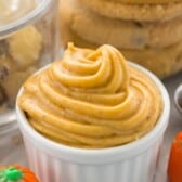 pumpkin frosting piped into a white ceramic dish.