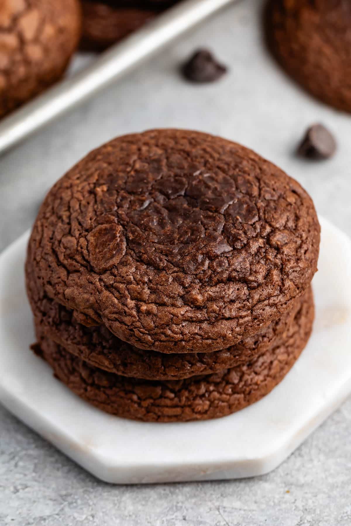 stacked brownie cookies laid on a white counter.