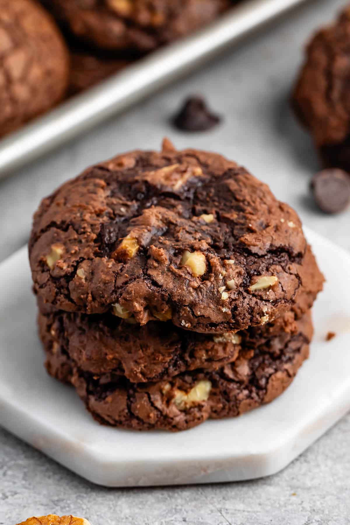 stacked brownie cookies laid on a white counter.