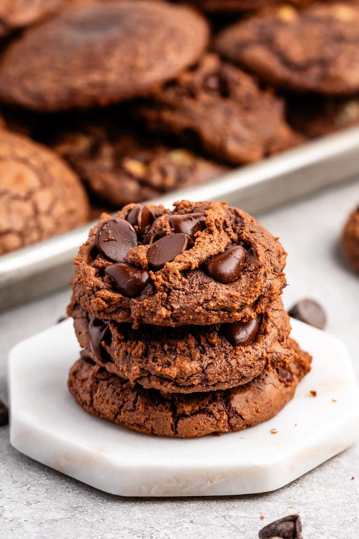 stacked brownie cookies laid on a white counter.