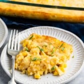 corn casserole on a grey plate with a fork.