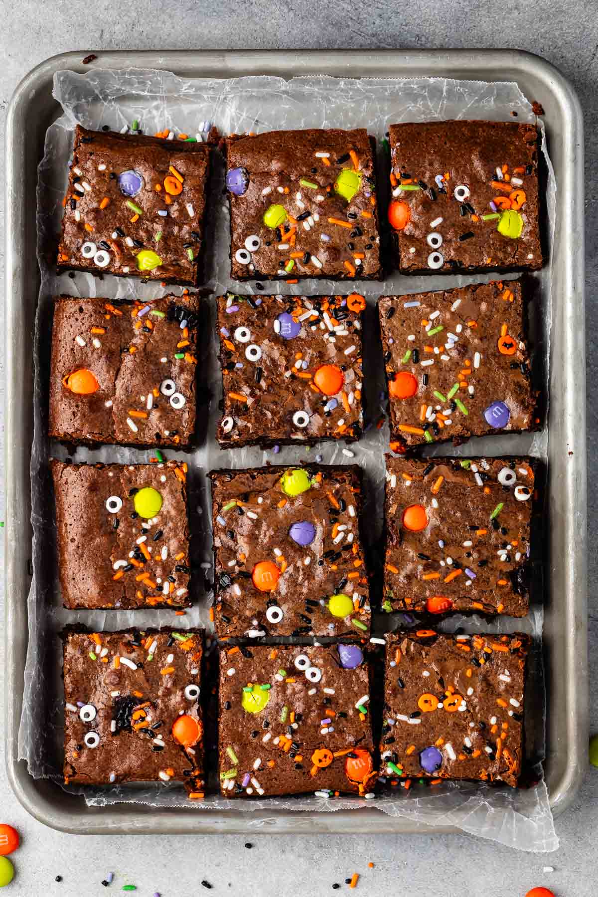 layered brownies on a sliver baking pan with halloween candy baked in.