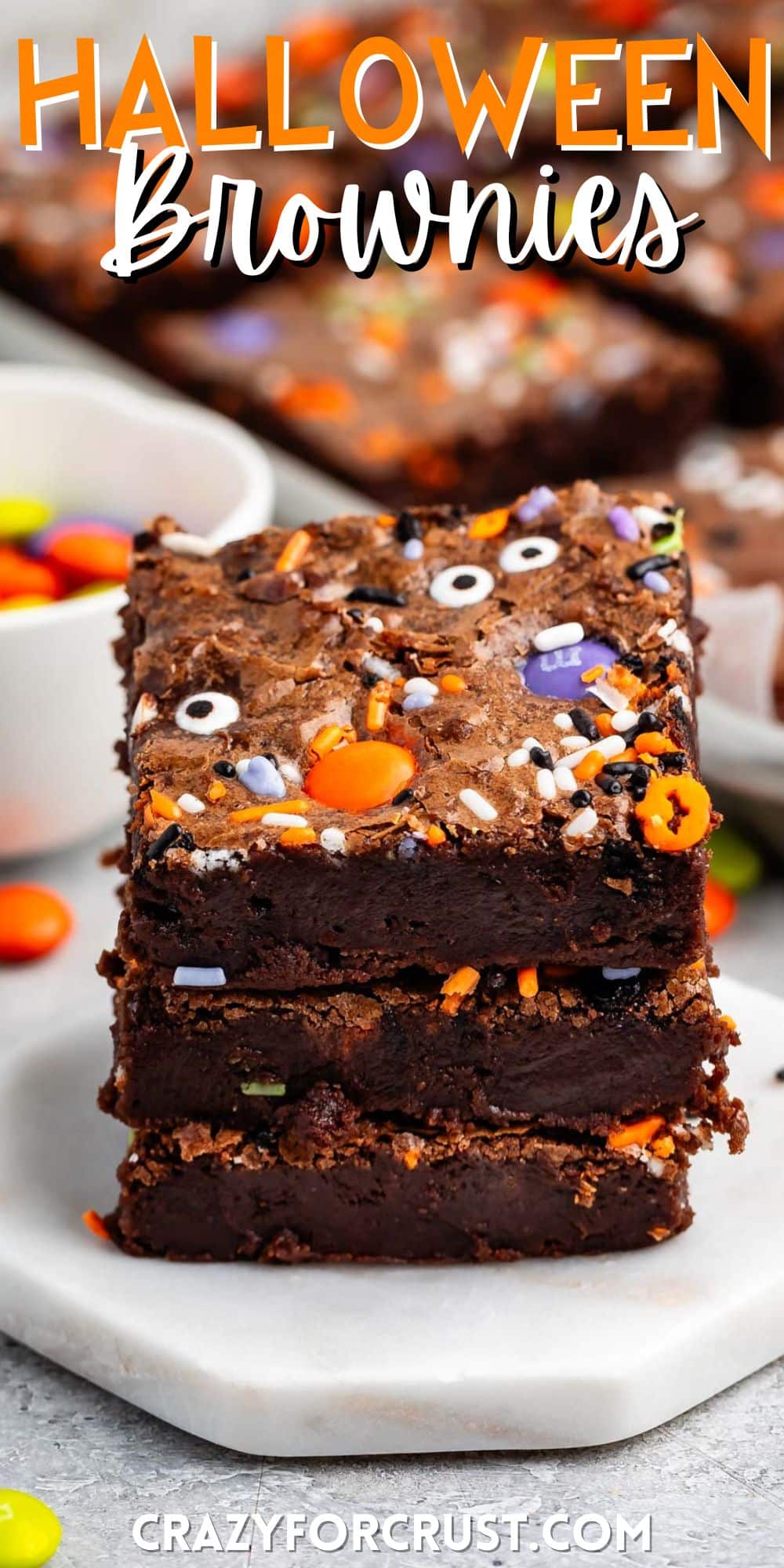 stacked brownies with halloween candy baked in with words on the image.