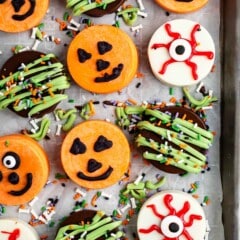 Oreos covered in different colored chocolate forming pumpkins and eyes for halloween.