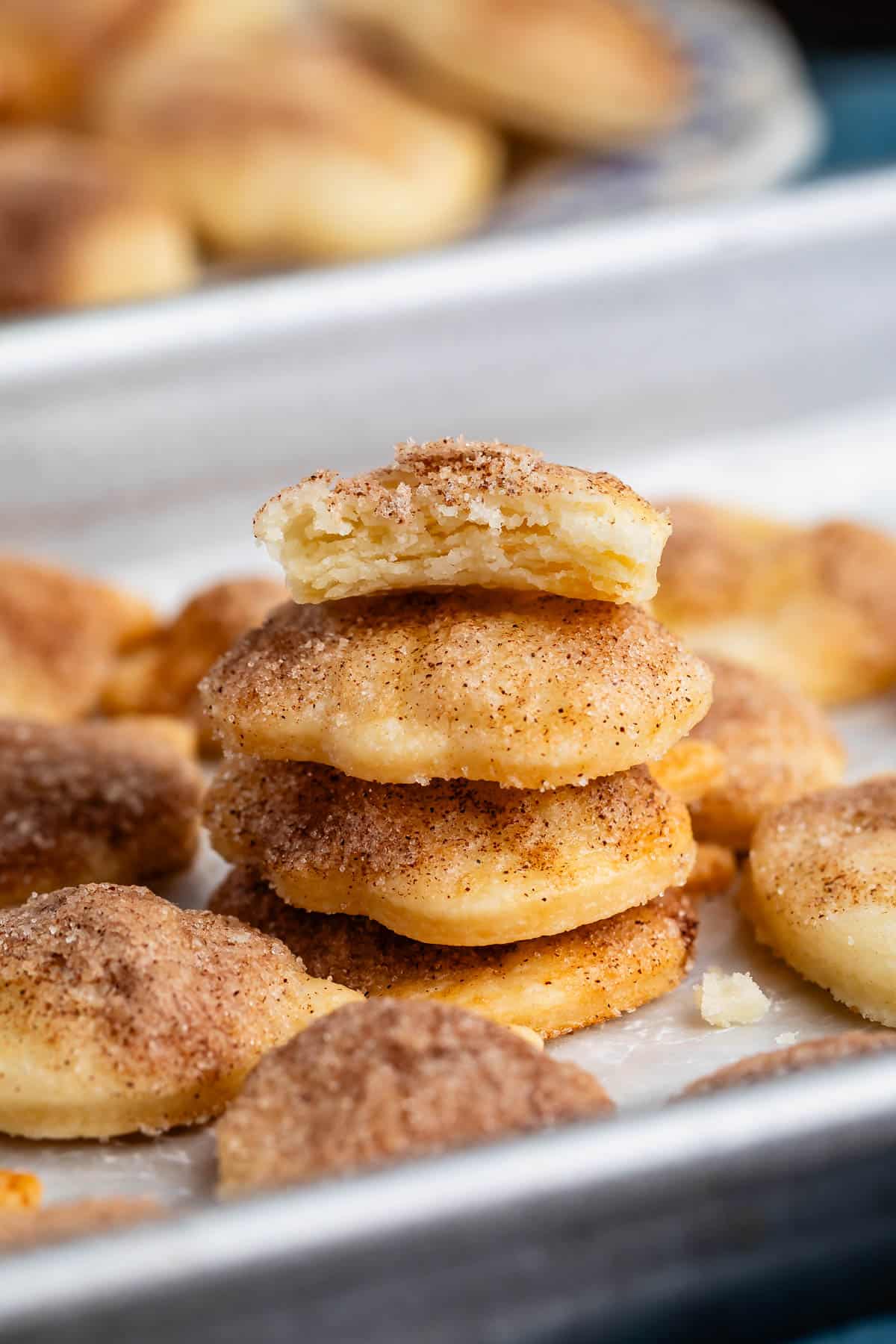 pie crust cookies covered in cinnamon on a silver baking pan.