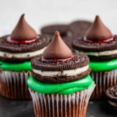 cupcakes with green frosting and a Oreo and kiss on top.