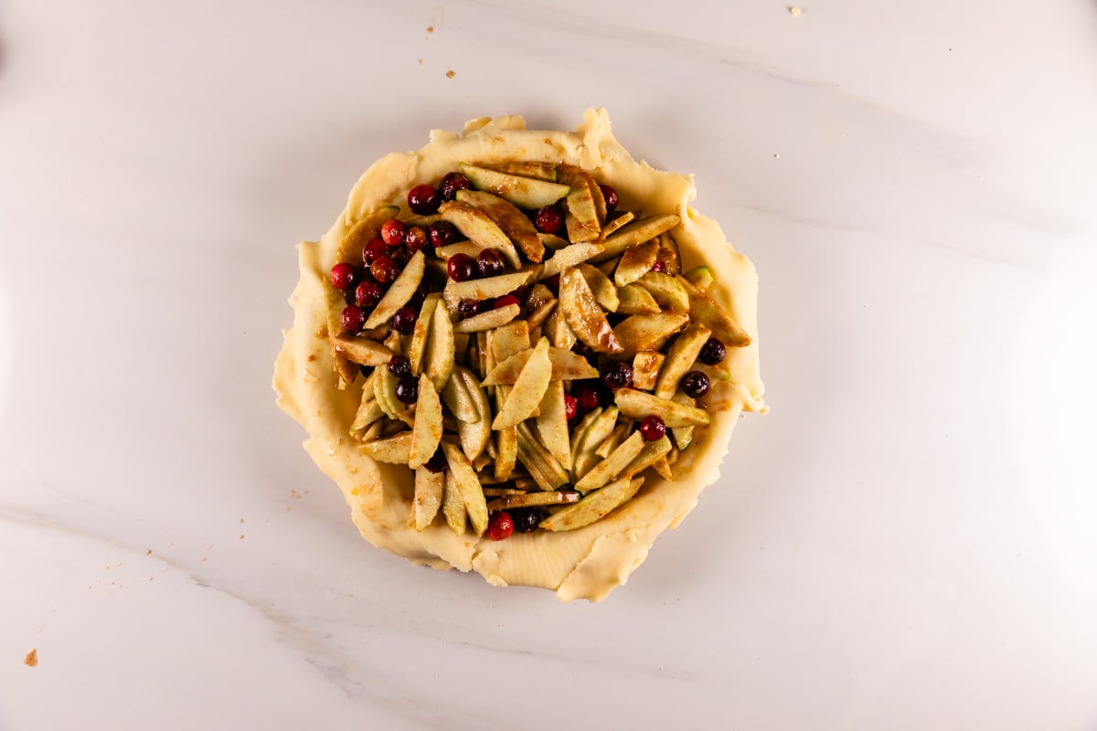 process shot of apple cranberry pie being made.