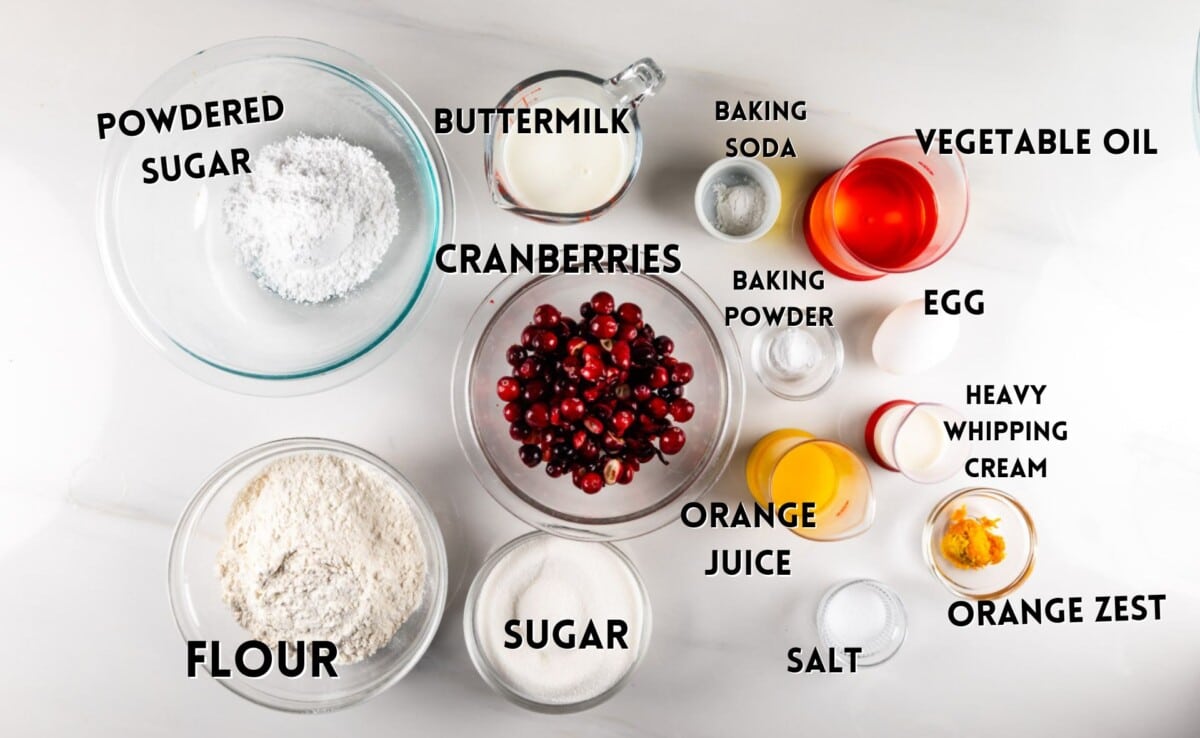 ingredients in cranberry orange bread laid out on a white counter.