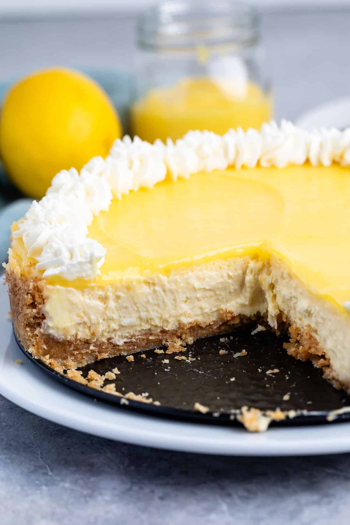 lemon cheesecake with lemon curd and whipped cream on top.