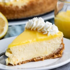 lemon cheesecake with lemon curd and whipped cream on top.