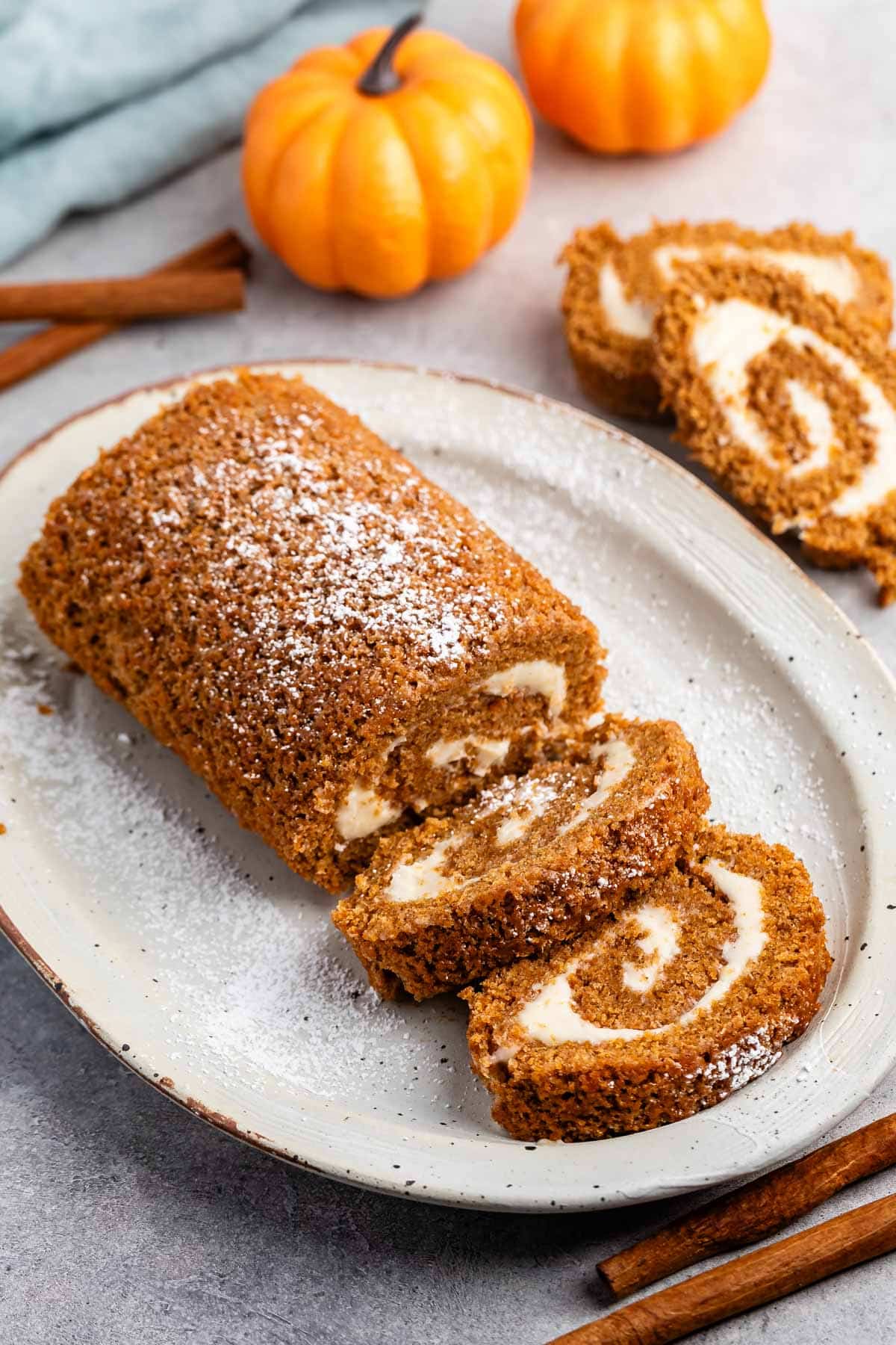 sliced pumpkin cake roll with a white buttercream in the center.