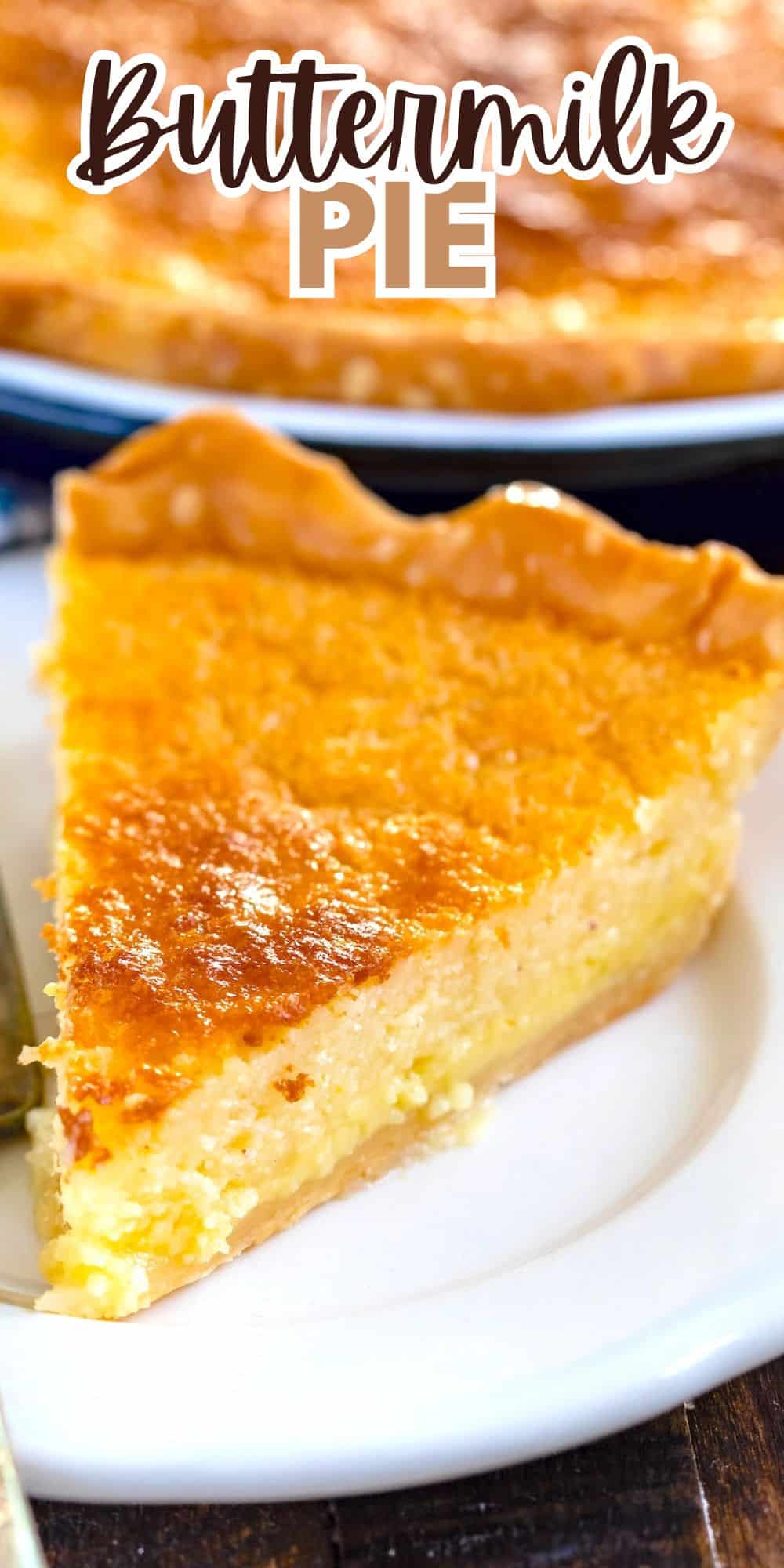 A slice of golden brown buttermilk pie on a white plate with a flaky crust, displayed in front of the rest of the pie. The text Buttermilk Pie is written in stylized font at the top.