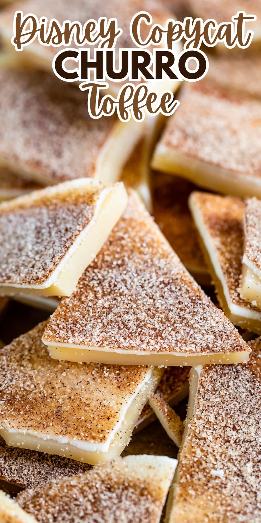 Close-up of several pieces of churro toffee, each topped with a cinnamon sugar coating. The toffee is arranged in overlapping layers, showcasing its creamy texture and sprinkled surface. Text at the top reads Disney Copycat Churro Toffee.