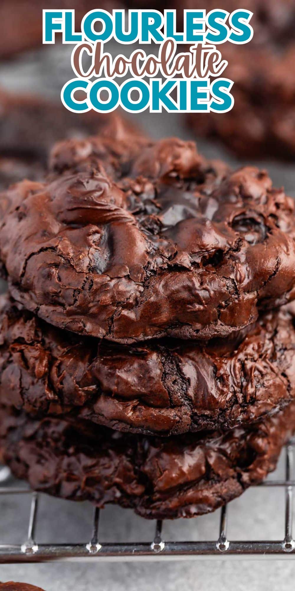 Close-up of a stack of rich, fudgy flourless chocolate cookies with a glossy texture. The text Flourless Chocolate Cookies is displayed at the top in bold blue and white font. The cookies are resting on a cooling rack.