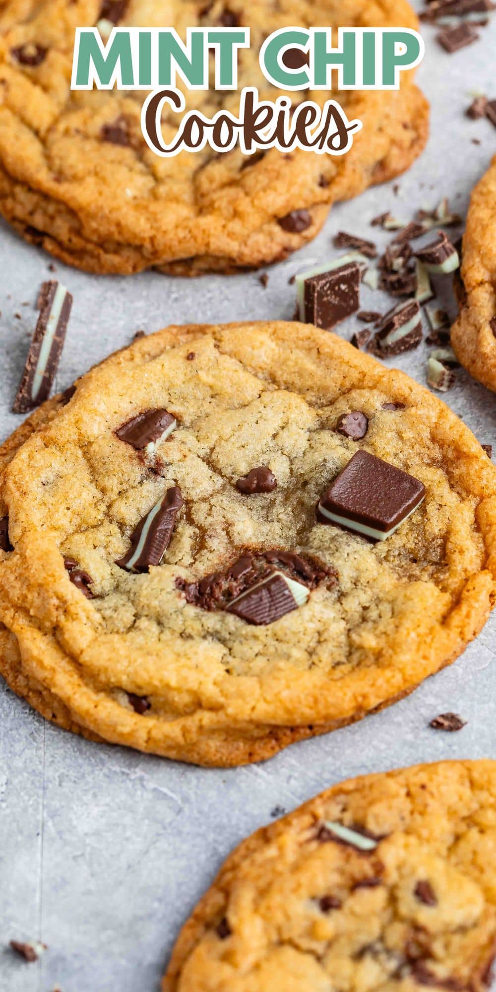 Close-up of freshly baked mint chip cookies on a baking sheet. The cookies are golden brown with visible pieces of chocolate and mint chips. A text overlay at the top reads Mint Chip Cookies.