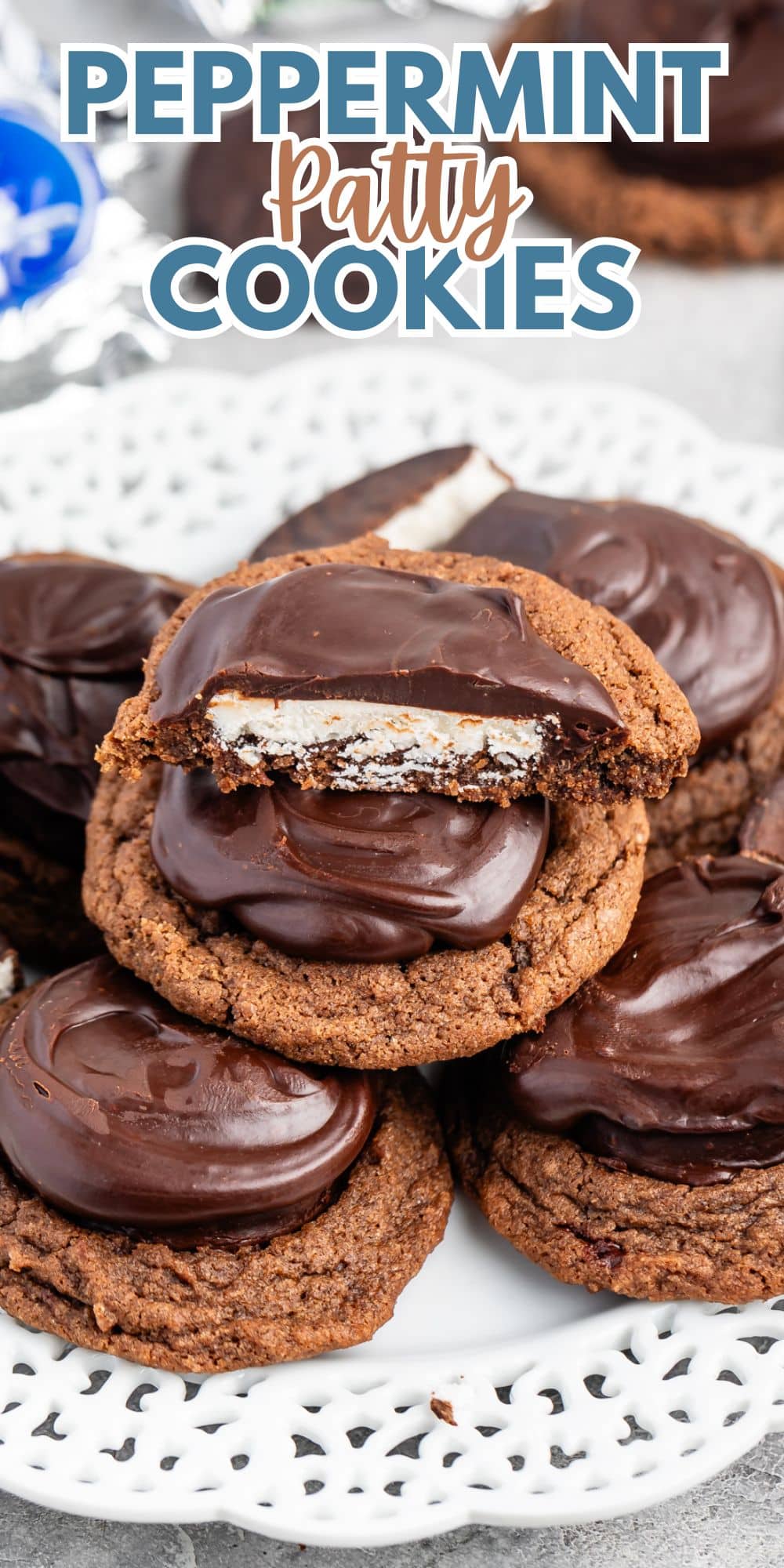 A stack of chocolate cookies topped with peppermint patties on a white lace-patterned plate. The top cookie is partially eaten, revealing a white peppermint filling. The text above reads Peppermint Patty Cookies.