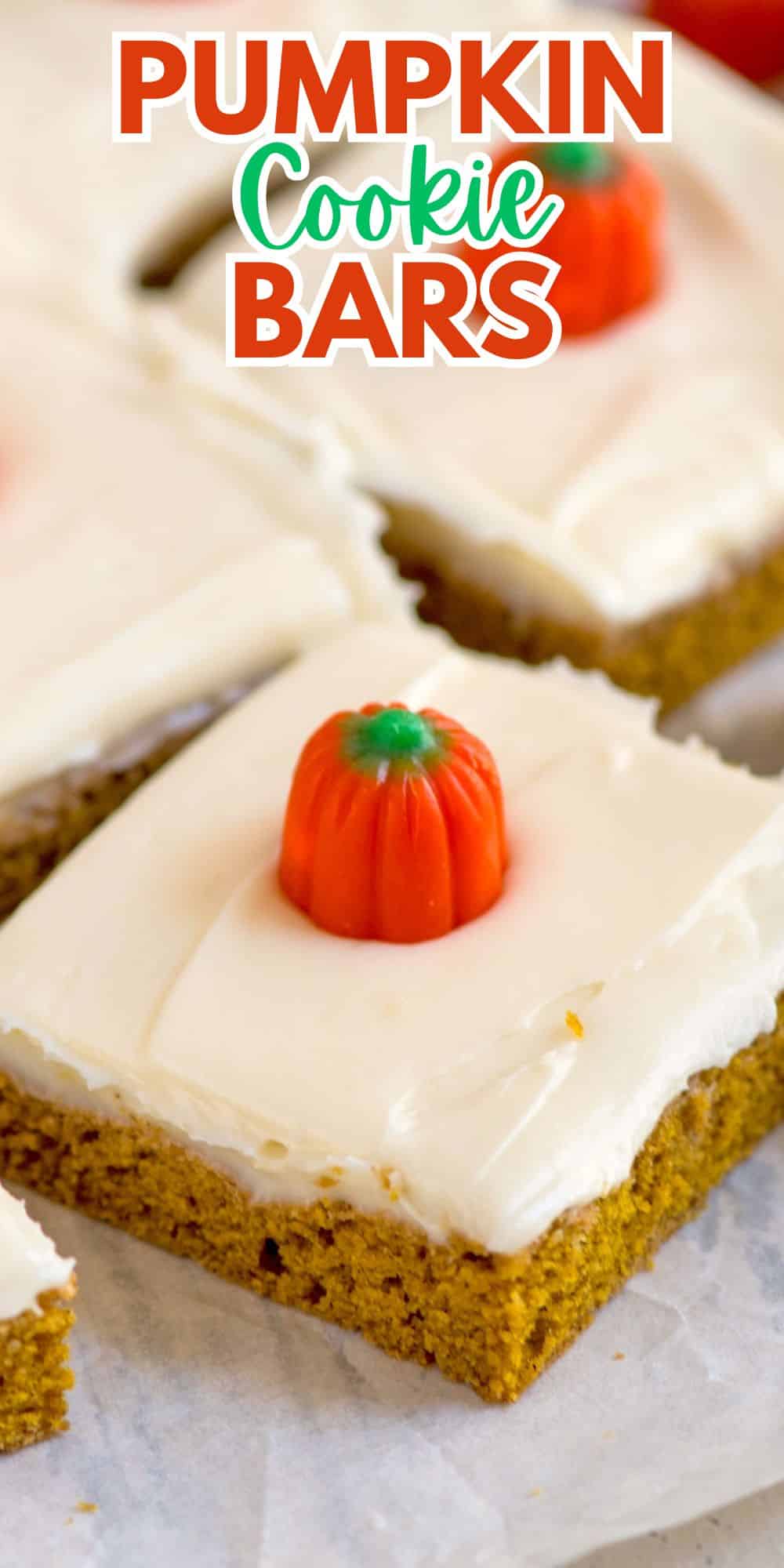 Close-up of pumpkin cookie bars topped with cream cheese frosting and decorative pumpkin candies. The text Pumpkin Cookie Bars is written at the top of the image.