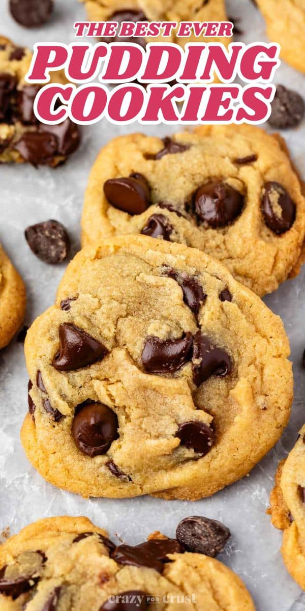 Close-up of freshly baked cookies with chocolate chips on a parchment-lined surface. Text at the top reads The Best Ever Pudding Cookies.