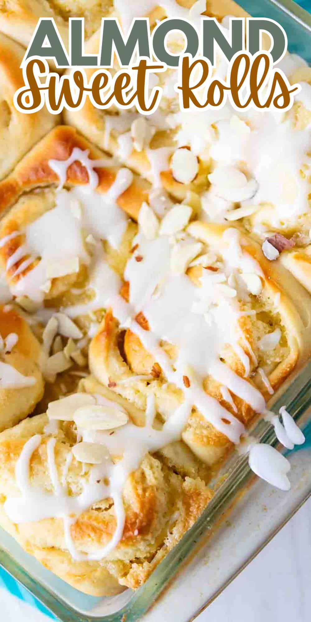 A glass baking dish filled with almond sweet rolls topped with white icing and sliced almonds. The text Almond Sweet Rolls is at the top. The rolls are golden brown and closely packed.