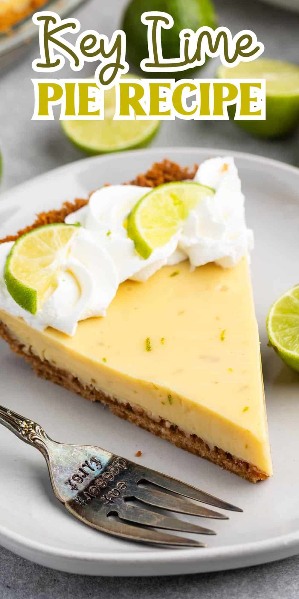 A slice of key lime pie on a white plate, garnished with whipped cream and lime slices. A fork rests on the plate beside the pie. The background features more slices of lime. Text at the top reads Key Lime Pie Recipe.